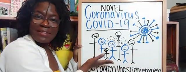 Raven Baxter, in a white lab coat and glasses, gestures toward a whiteboard titled Novel Coronavirus COVID-19, with stick figures and a drawn virus.