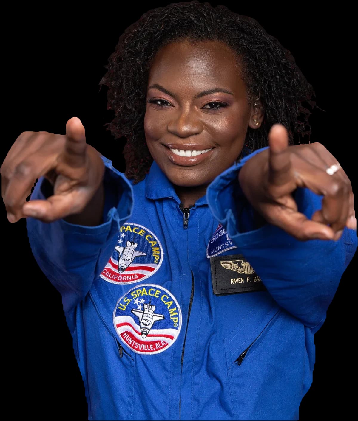 Dr. Raven Baxter in a Space Camp flight suit, pointing at the camera