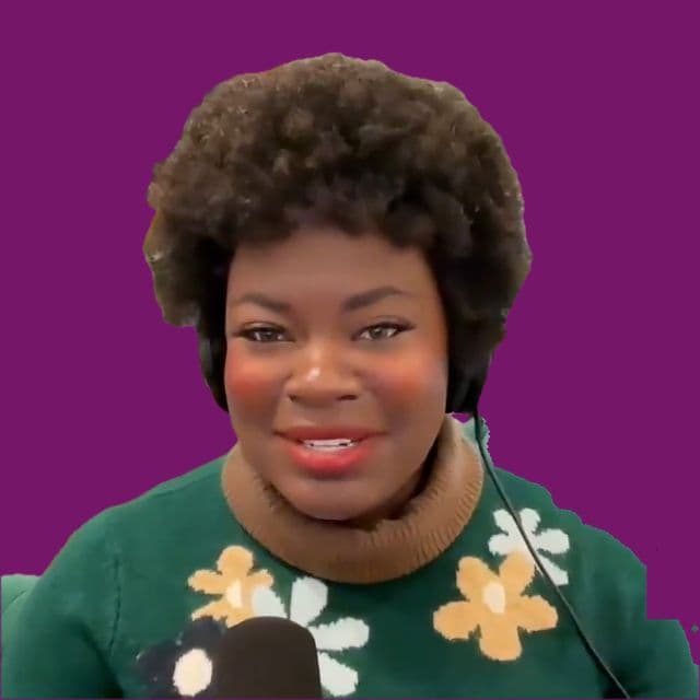 Dr. Raven Baxter in a flowered sweater at a microphone