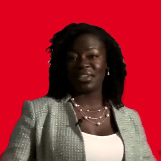 Dr. Raven Baxter speaking on camera in a tweed jacket