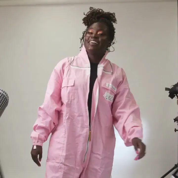 Dr. Raven Baxter laughing in a pink beekeeping suit on a studio set, from the Nerdy Jobs trailer