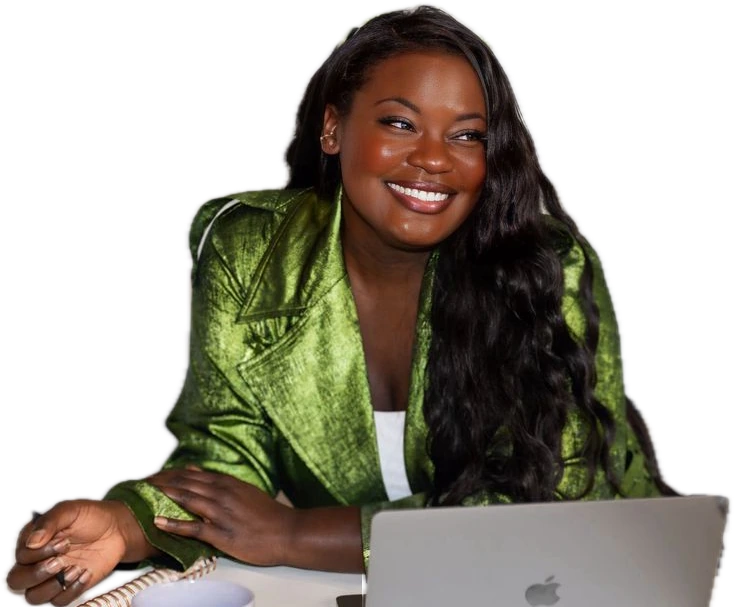 Dr. Raven Baxter smiling at her desk, notebook and laptop open